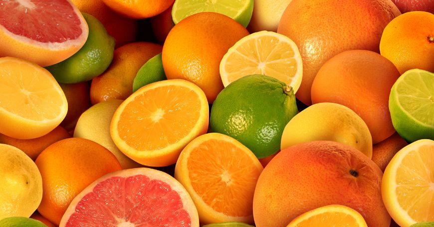 Varietà di agrumi come arance, lime, limoni e pompelmi interi e tagliati, perfetti per approfondire il tema colite e alimentazione