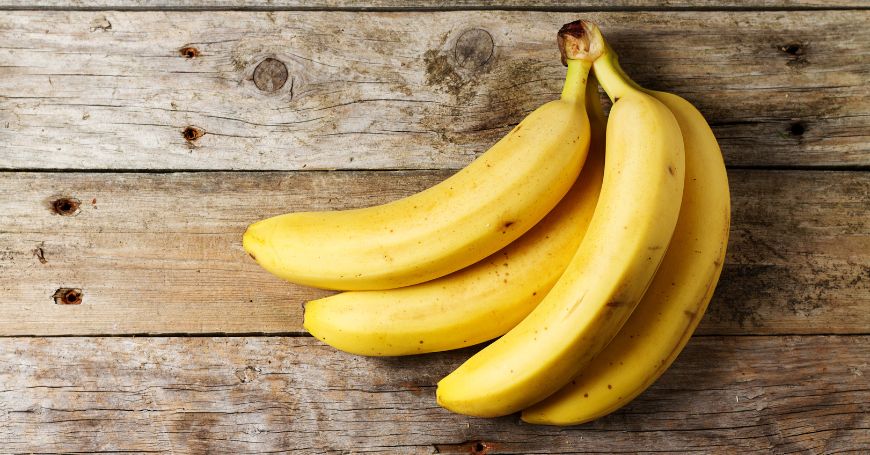 Banane su superficie in legno, perfette per una dieta equilibrata e benefica per l’intestino